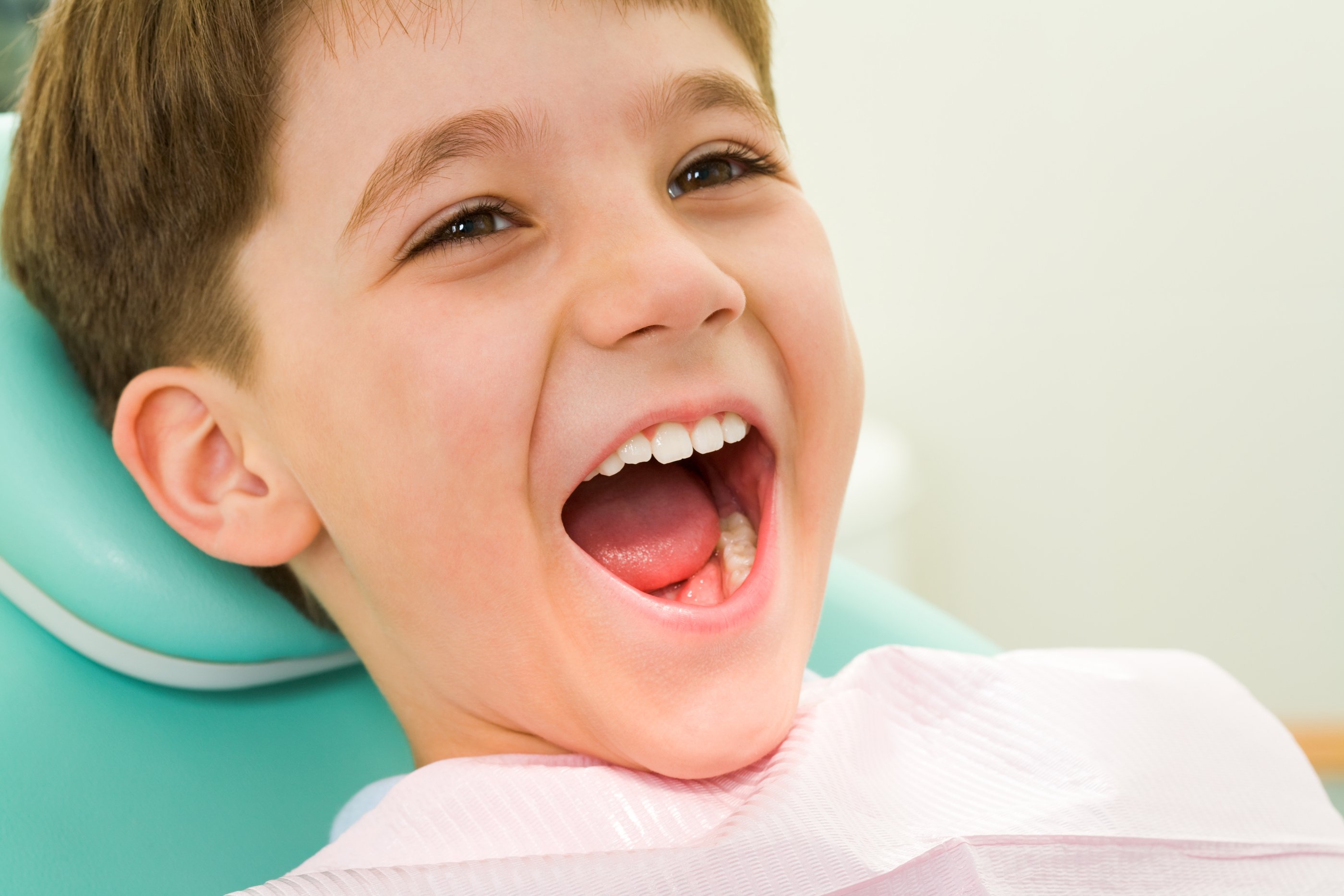 Photo of youngster with his mouth wide open during checkup at the dentists